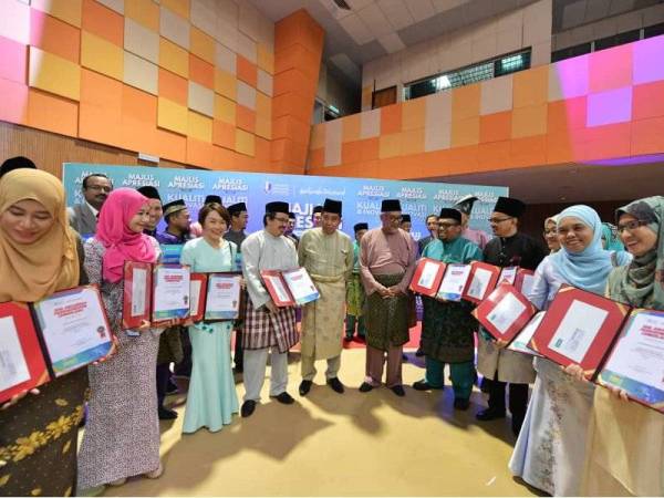 Ibrahim Ahmad (tengah) dan Ir Dr Wan Azhar bersama sebahagian penerima APC dan penerima anugerah kecemerlangan pada majlis itu di Dewan Kompleks Sukan, UMP Kampus Gambang kelmarin.