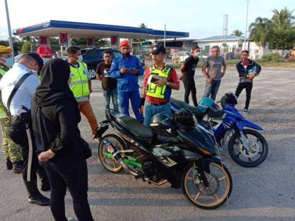 Anggota bertugas sedang melakukan pemeriksaan ke atas motosikal Ysuku yang ditahan dalam Operasi Motosikal di Jalan Benting Lintang, Jerteh, Besut, Jumaat lalu - Foto Ihsan IPD Besut