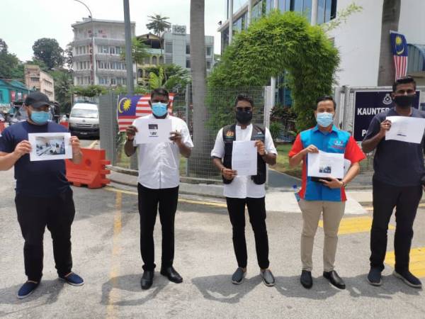 Prabakaran (tengah) menunjukkan laporan polis yang dibuat di Ibu Pejabat Polis Daerah Sentul, Kuala Lumpur hari ini.