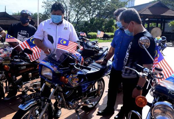 Mazlan (tengah) melihat kenderaan yang memakai nombor plat khas 'UTM' selepas merasmikan Konvoi Merdeka UTM di Dapur Lesung, Kompleks Warisan Sultan Abu Bakar hari ini.
- FOTO: BERNAMA 