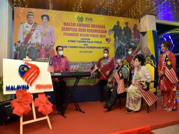 Tuanku Syed Sirajuddin (duduk, kiri) bersama Raja Perempuan Perlis Tuanku Tengku Fauziah Tengku Abdul Rashid (duduk, kanan) berkenan mendengar alunan piano lagu 'Malaysia Prihatin' yang dimainkan Pengarah Okestra RTM, Datuk Mokhzani Ismail (kiri) sebagai simbolik pelancaran Majlis Sambutan Ambang Merdeka sempena Sambutan Hari Kebangsaan 2020 peringkat Perlis malam tadi. - Foto Bernama