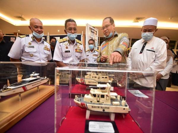 Mohd Zubil (dua dari kiri) mengiringi Ahmad Amzad (dua dari kanan) melawat pameran Maritim Malaysia di Galeri Skybridge di jambatan angkat Terengganu di sini malam tadi. - Foto Urusetia Penerangan Darul Iman (UPDI)