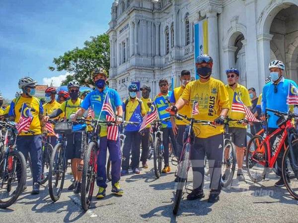 Tuanku diiringi Tung Seang (kiri) mengayuh basikal sejauh 18 km sempena Sambutan Hari Kebangsaan ke-63 di Georgetown, hari ini.