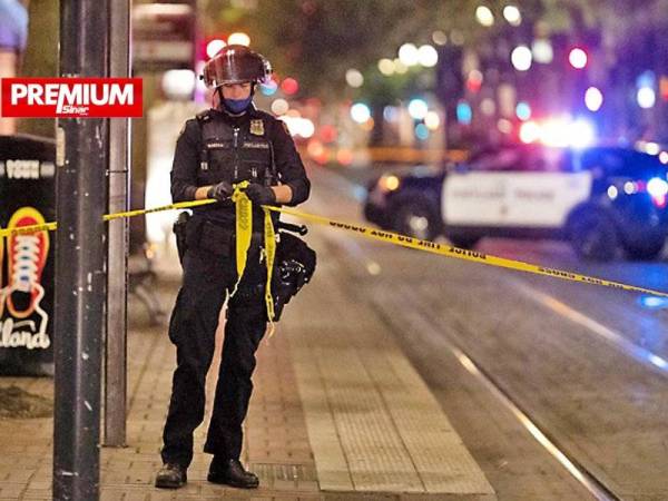 Seorang anggota pihak berkuasa berdiri di tepi garisan polis di lokasi kejadian tembakan di Portland, Oregon pada Sabtu lalu. - Foto AFP