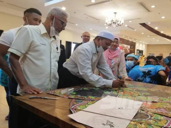 Ariffin (dua dari kiri) cuba membuat wau sobek sempena Majlis Pelancaran Wau Sobek @ Permai Hotel.