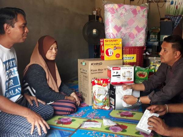 Zamzuri (dua dari kanan) memberikan kata-kata semangat kepada Sufiza (dua dari iri) dan Azizan (kiri) ketika ditemui di rumahnya di Kampung Kuala Lanjut, Pokok Sena.