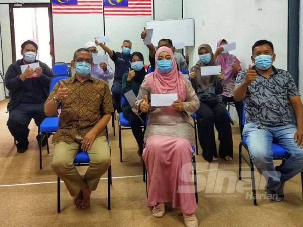 Halimaton Shaadiah (tengah) bergambar bersama penerima sumbangan UA/IPTS DUN Bukit Kayu Hitam di sini hari ini.