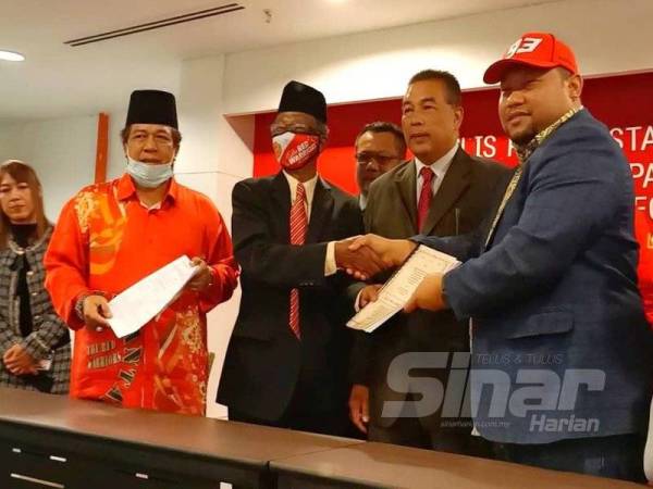 Norizam (kanan) bersama Ahli Lembaga Pengarah Team Red Warriors Sdn Bhd, Datuk Wan Abdul Rahim Wan Abdullah menunjukkan dokumen perjanjian pemilikan saham penuh ke atas pasukan Kelantan.