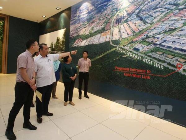 Solihan (tengah) melihat pelan pembangunan semasa melawat Frontier Industrial Park Desa Cemerlang Tiram di Ulu Tiram, hari ini.