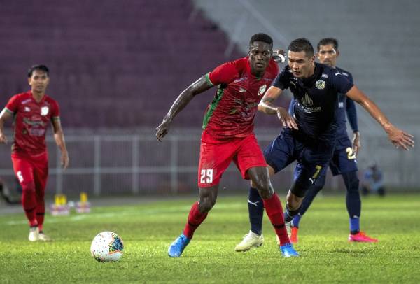 Pemain Kelantan United FC, Alfusainey Gassama (dua, kiri) dihalang oleh pemain Kuala Lumpur, Azammat Baimatov (kanan) pada perlawanan Liga Premier di Stadium Sultan Muhammad Ke-IV malam tadi. - Foto Bernama