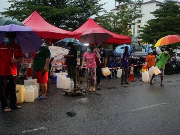 Penduduk Sri Manja beratur mengambil bekalan air dari tangki yang telah disediakan oleh Pengurusan Air Selangor Sdn Bhd setelah penduduk sekitar mengalami gangguan bekalan air. - Foto Bernama