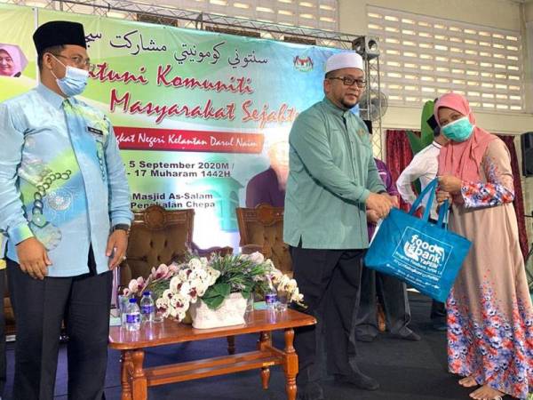 Ahmad Marzuk menyampaikan sumbangan kepada wakil keluarga asnaf yang terpilih sempena program Santuni Komuniti Masyarakat Sejahtera di Masjid As-Salam Pengkalan Chepa hari ini.