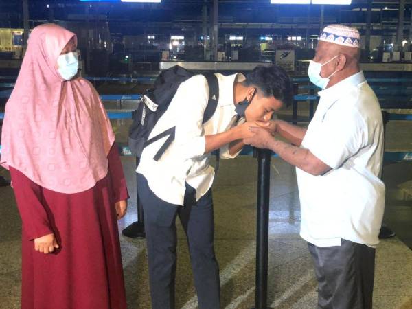 Luqman mencium tangan Shamsudin sambil diperhatikan Hasmah sebelum berlepas ke Belgium di Lapangan Terbang Antarabangsa Kuala Lumpur (KLIA) pada 13 Ogos lalu.