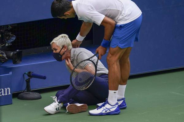 Djokovic melihat keadaan penjaga garisan yang terkena bola pukulannya pada Terbuka Amerika Syarikat di Flushing Meadows.