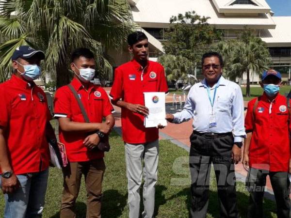 Thiaga (tiga kiri) menyerahkan memorandum untuk tindakan kerajaan negeri kepada Samsudin di pintu masuk Bangunan Dato' Abdul Rahman Andak, Kota Iskandar, Iskandar Puteri, hari ini.