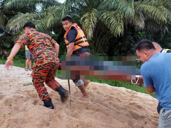 Anggota bomba mengangkat mayat mangsa lemas di Sungai Segamat petang tadi.