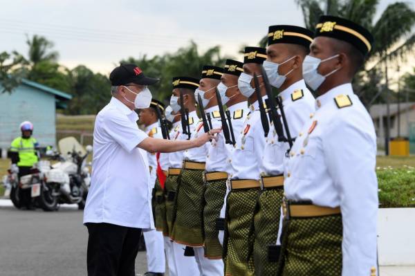 Ismail Sabri (kiri) membetulkan pingat perkhidmatan anggota kawalan kehormat sewaktu mengadakan lawatan ke Kem Sri Kinabatangan sempena lawatan kerja ke Sandakan hari ini. - Foto Bernama