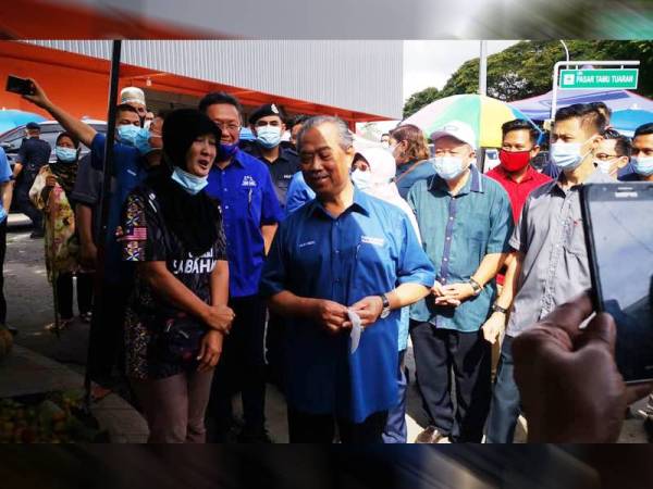 Perdana Menteri berbual bersama salah seorang peniaga, Tainah Makdan ketika lawatan beliau di Pasar Am Tuaran hari ini.