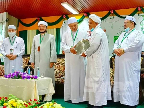 Nik Zawawi (dua dari kiri) bersama Ahmad (tiga dari kiri) menyampaikan anugerah kepada salah seorang penerima semasa Muktamar Tahunan Dewan Ulama Pas Kali ke-59 di Markaz Dewan Ulama (MADU) Kelantan di Pulai Chondong.