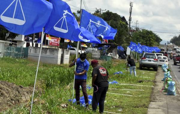 Petugas pilihan raya memasang bendera parti bertanding pada Pilihan Raya Negeri (PRN) Sabah ketika tinjauan hari ini. -Foto Bernama