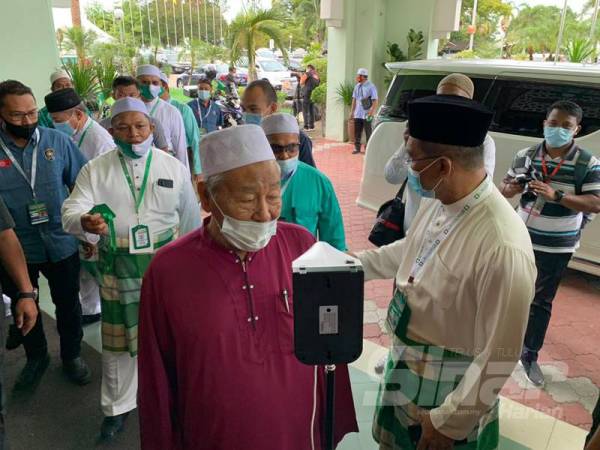 Hashim Jasin melakukan pemeriksaan suhu sebelum memasuki bangunan Putik pagi ini.