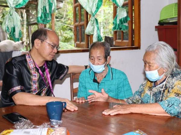 Madius (kiri) ketika bertemu ayahnya Yanggau Gokis (tengah) dan ibunya Belugu Panod (kanan) di rumahnya di Kampung Lokos semalam.