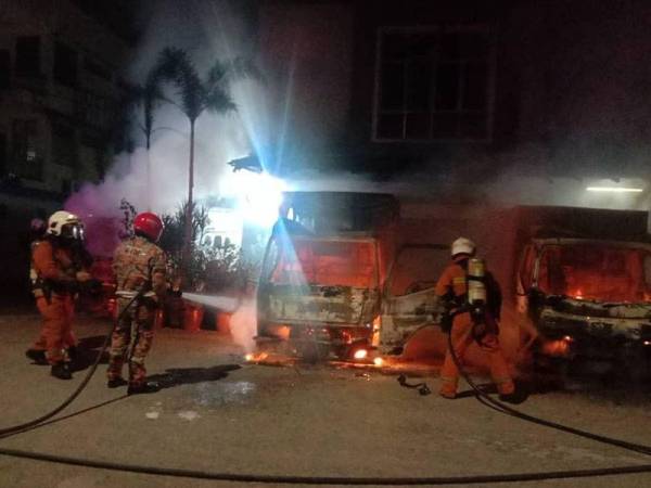 Anggota dari Balai Bomba dan Penyelamat Ipoh memadamkan api pada empat lori di hadapan sebuah kedai di Menglembu, Ipoh hari ini.