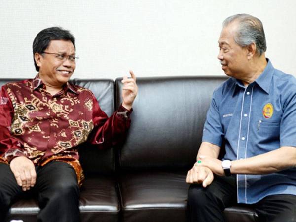 Mohd Shafie (kiri) berkata sesuatu kepada Muhyiddin (ketika itu menjawat jawatan Menteri Dalam Negeri) sewaktu menerima kunjungan hormat di Pejabat Ketua Menteri di Pejabat Pentadbiran Negeri Sabah pada 6 April 2019. - Foto Bernama