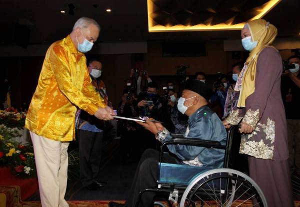 Sultan Nazrin Shah (kiri) berkenan menyampaikan sumbangan kepada Wira Negara yang juga veteran polis, Sulaiman Ahmad, 64, (dua dari kanan) pada Majlis Jamuan Teh dan Penyampaian Hadiah Sempena Sambutan Hari Kebangsaan Peringkat Negeri Perak Tahun 2020 di Pusat Konvensyen Casuarina Meru, Ipoh hari ini. - Foto Bernama