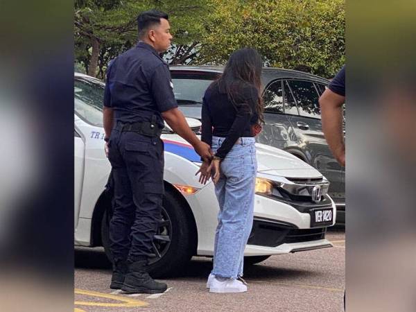 Suspek wanita yang ditahan selepas kereta Honda Jazz dipandu rakan lelakinya gagal meloloskan diri dibawa ke Ibu Pejabat Polis daerah (IPD) Kemaman. - Foto ihsan IPD Kemaman