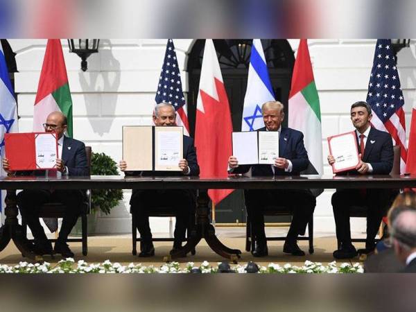 Trump (dua dari kanan); Netanyahu (dua dari kiri); Menteri Luar Emiriah Arab Bersatu, Abdullah bin Zayed Al Nahyan (kanan) dan Menteri Luar Bahrain, Abdullatif al-Zayani menunjukkan dokumen yang mereka tandatangani di Rumah Putih, Washington semalam. - Foto AFP