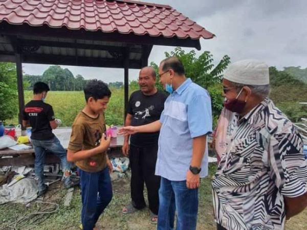 Ahmad Amzad (dua dari kanan) yang masih dalam cuti sakit akibat pembedahan baru-baru ini meluangkan masa melihat keadaan kerbau peliharaan keluarga Muhammad Syukur di Kampung Banggol Katong, Serada hari ini. - Foto Facebook Ahmad Amzad