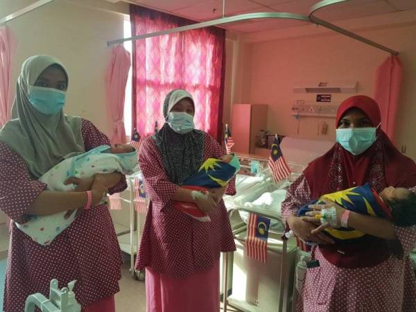 Amelia (kiri) bersama Norashikin (tengah) dan Norhayati berbangga mendukung bayi mereka yang dilahirkan pada sambutan Hari Malaysia di Hospital Putrajaya hari ini.