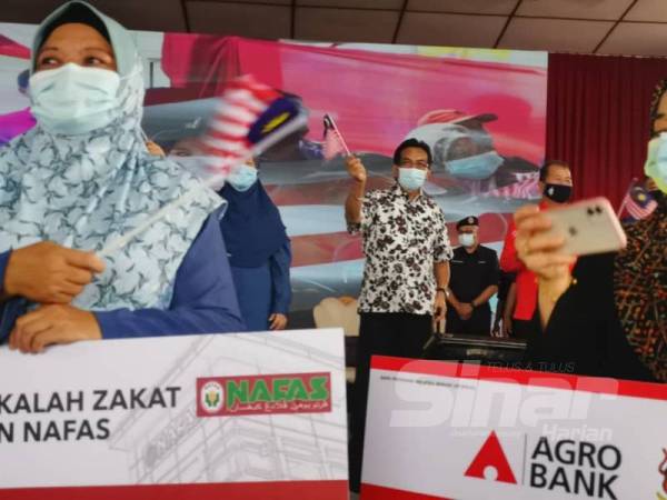 Musa bersama-sama mengibarkan bendera dan menyanyikan lagu Jalur Gemilang di atas pentas ketika Program Perdana Menteri Bersama Peladang, Penternak dan Nelayan Sabah serta Pelancaran Skim Subsidi Baja dan Racun Padi Bukit/Huma di Dataran Bagandang, Beaufort.