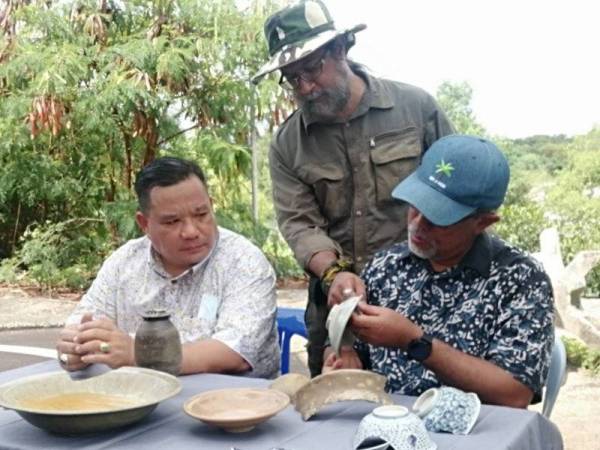 Akramuddin (kiri) melihat tembikar dan porselin berusia lebih 900 tahun yang berjaya ditemui di Melaka Raya, di sini, hari ini.