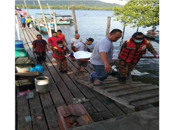 Nelayan membantu anggota dari Balai Bomba dan Penyelamat Ayer Tawar membawa mayat mangsa naik ke tebing.