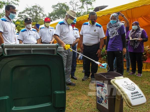 Tuanku Muhriz (depan, tiga dari kanan) melakukan gimik pelancaran World Cleanup Day dan Pelancaran Kempen Negeri Sembilan Bersih di Taman Malaysia sambil diperhatikan Aminuddin (depan, dua dari kanan). 