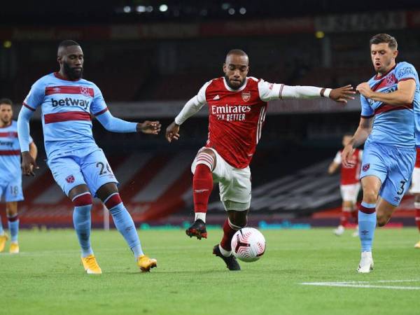 Lacazette (tengah) ketika cuba melepasi dua pemain West Ham United pada aksi di Stadium Emirates.