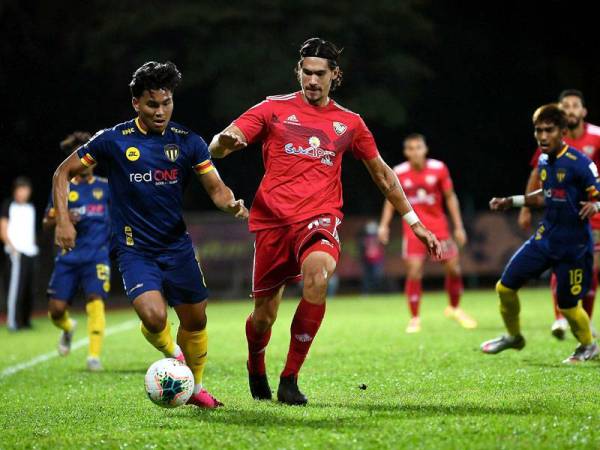 Pemain Terengganu FC, Muhammad Arif Fadzilah Abu Bakar (kiri) cuba mengawal bola dari pemain UiTM FC, Mark Andrew Hartmann pada aksi CIMB Liga Super di stadium UiTM malam tadi.