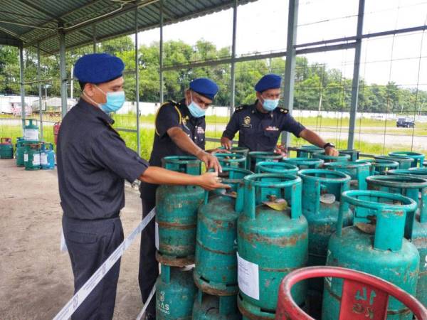 Muniandy tengah melihat tong LPG yang dirampas ketika serbuan di Kampung Changhai semalam.