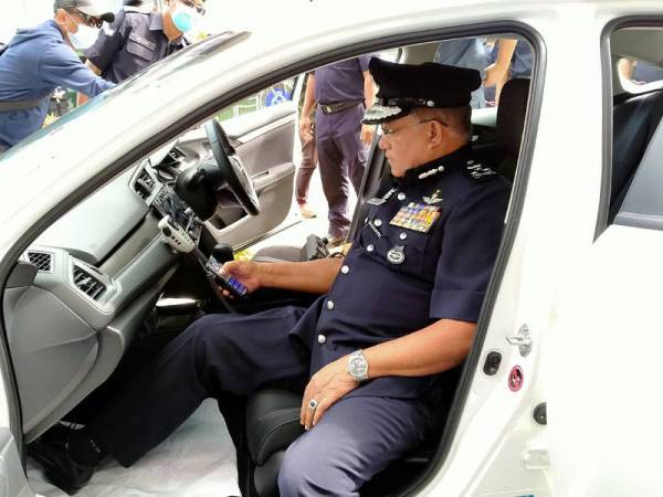 Zainal memeriksa kenderaan MPV Honda Civic 1.8S sebelum membuat penyerahan di Sekolah Latihan Asas Kepolisan Kuala Muda, Sungai Petani hari ini.