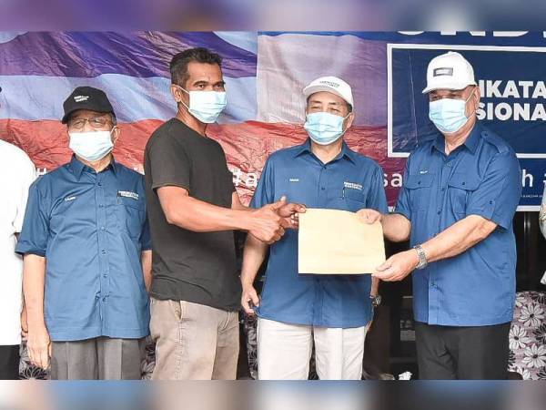 Hajiji (dua dari kanan) menyaksikan penyerahan borang kemasukan ahli Warisan ke Bersatu dalam program Sayangi Sabah Bersama Bersatu di Kampung Pengalat Besar, Papar.