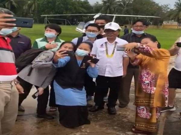 Shafie bergambar bersama guru dan murid SMK Tamparuli yang menyambut ketibaannya.