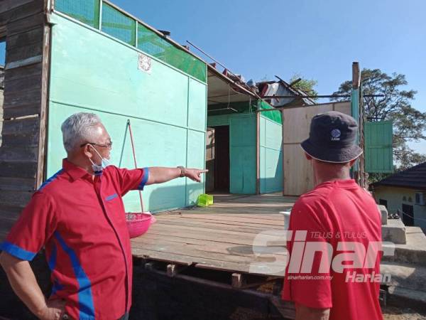 Noh (kiri) ketika menziarahi rumah penduduk yang terkesan akibat ribut kelmarin di Kampung Limau Manis hari ini.