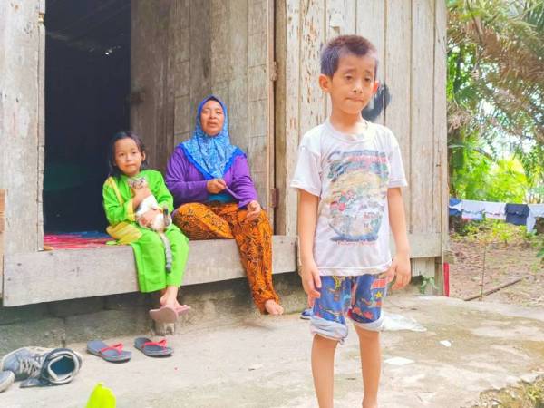 Wan Sharifah bersama anak perempuannya dan Mohd Shariman (hadapan) yang mengalami masalah pundi kencing atau nephrotic syndrome dan penyakit buah pinggang di rumah sewanya di Kampung Permatang Gading, Bukit Abal, Pasir Puteh.