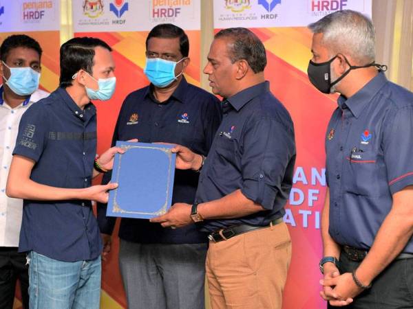 Saravanan (dua dari kanan) menyampaikan sijil tawaran mengikuti latihan di syarikat yang terpilih kepada Nur Azmi Daud (dua dari kiri) pada Program Inisiatif Penjana Pembangunan Sumber Manusia Berhad di Johor Bahru hari ini.