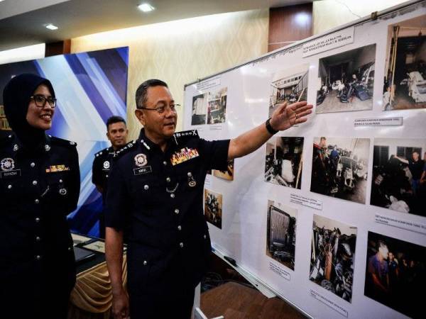 Saiful Azly (kanan) menunjukan gambar barang rampasan pada sidang media Kejayaan Jabatan Siasatan Jenayah (JSJ) Kuala Lumpur melibatkan tiga kes jenayah berlainan di Ibu Pejabat Polis Kontinjen Kuala Lumpur hari ini. - Foto Bernama