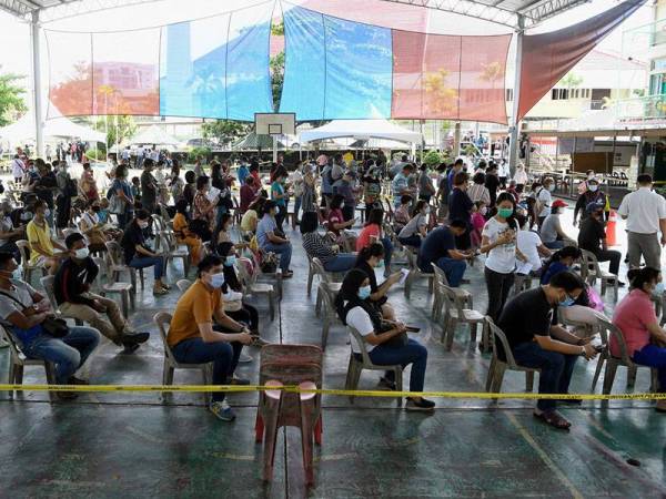 Penduduk menjalankan tanggungjawab keluar mengundi bagi Pilihan Raya Negeri (PRN) Sabah ke-16 dengan mematuhi SOP yang ditetapkan bagi membendung penularan pandemik Covid-19, di SK Sacred Heart hari ini. - Foto Bernama