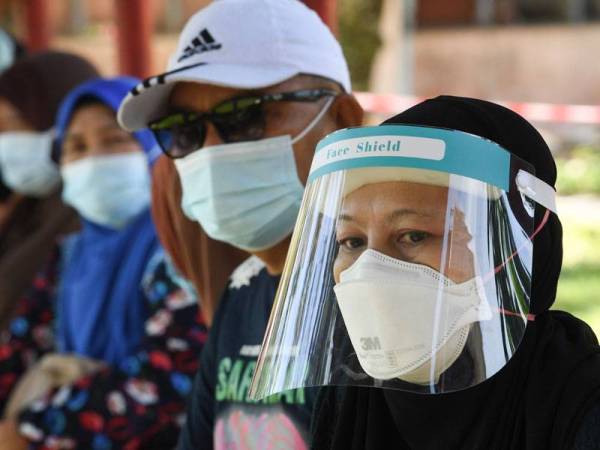 Gelagat pengundi memakai pelindung muka sewaktu menunggu giliran pada Pilihan Raya Negeri Sabah Ke-16 di Sekolah Menengah Kebangsaan Bukit Garam hari ini. Foto Bernama