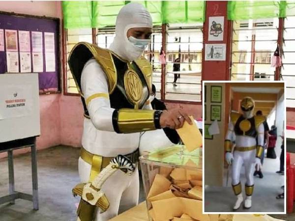 Telatah seorang pengundi di SMK Tansau yang mengenakan kostum adiwira ‘Power Rangers’ berwarna putih dilengkapi pedang mainan menarik perhatian orang ramai. - Foto ihsan pembaca